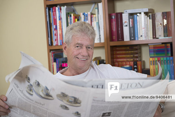Senior Senioren Portrait Mann lächeln Zeitung vorlesen