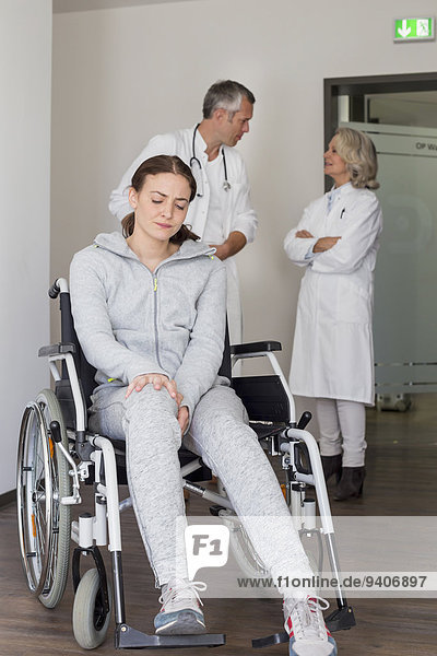 Patient in wheelchair  doctors in discussing background