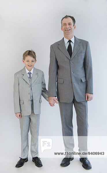 Father and son holding hands  smiling  portrait