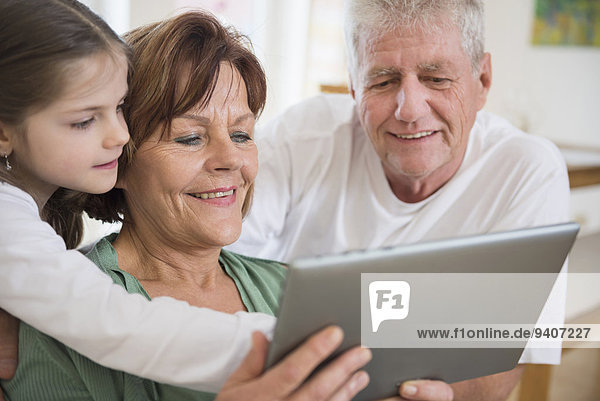 sehen lächeln Großeltern Enkeltochter Tablet PC