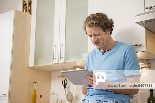 Man using digital tablet in kitchen