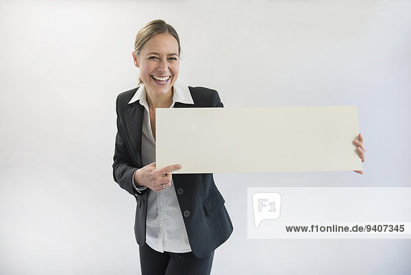 Portrait Geschäftsfrau lächeln halten schwarz Reklameschild unbeschrieben