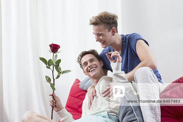Homosexual couple with red rose  smiling
