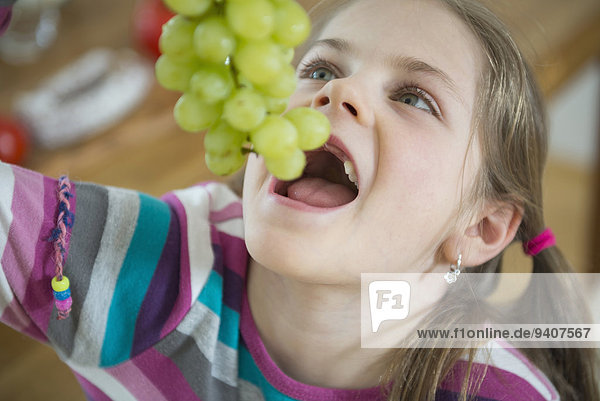 Girl eating bunch of grapes  close up