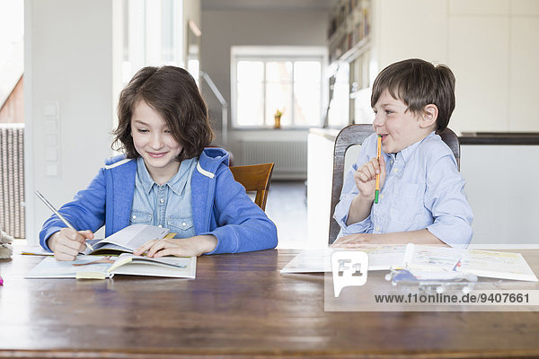 Girl and boy doing their homework  smiling