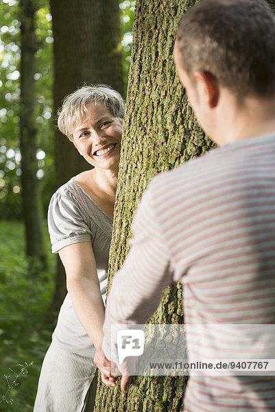 Mature couple playing in forest  smiling