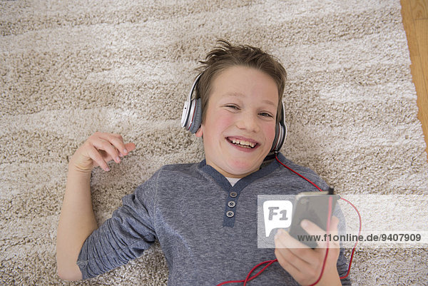 Boy at home listening to music from smartphone