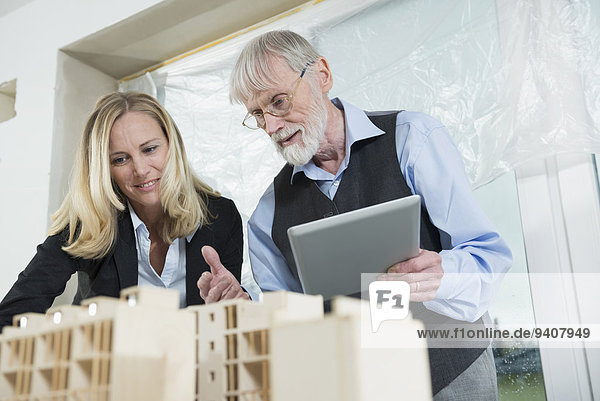 Two architects looking at architectural model