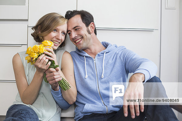 Happy woman receiving bunch of roses from man