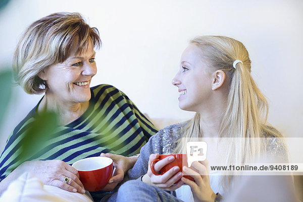 Grandmother and granddaughter in conversion on couch