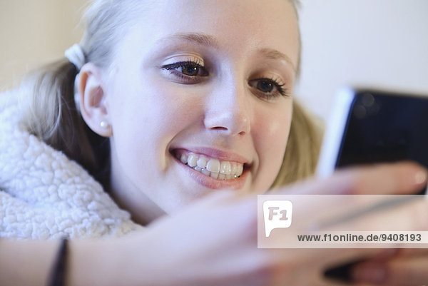 benutzen Jugendlicher lächeln Couch Smartphone Mädchen