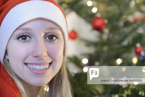 Portrait Jugendlicher lächeln frontal Weihnachtsbaum Tannenbaum Mädchen