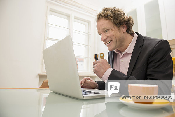 Man in suit with laptop and credit card