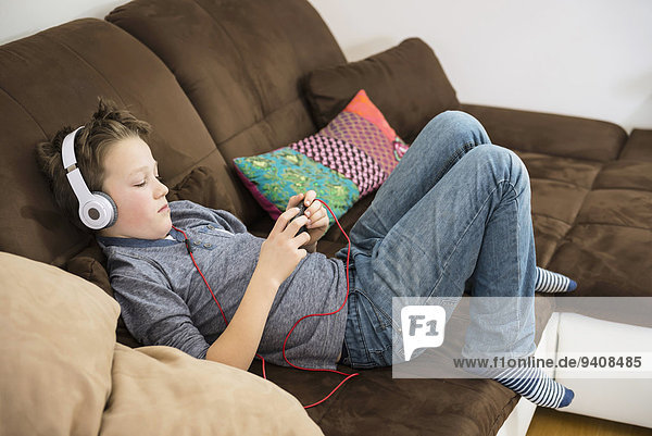 Junge - Person Kopfhörer Couch Smartphone