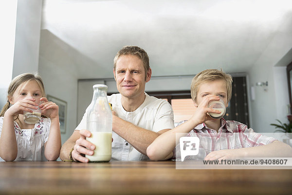 Father and his children drinking milk