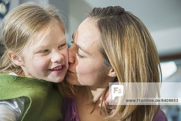 Mother kissing her daughter
