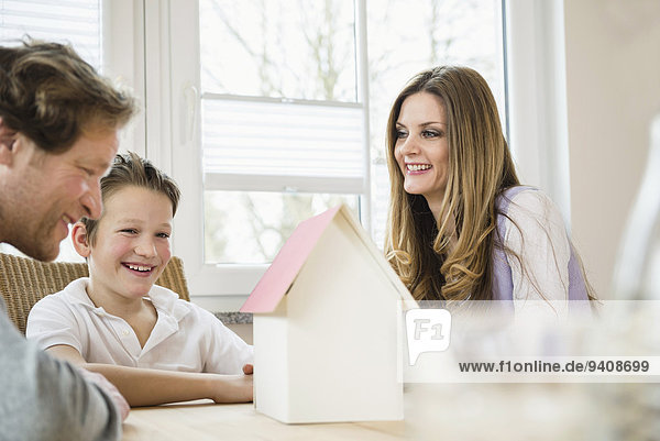 Family with architectural model at table