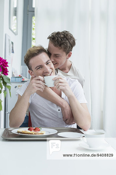Homosexual couple having breakfast together  smiling