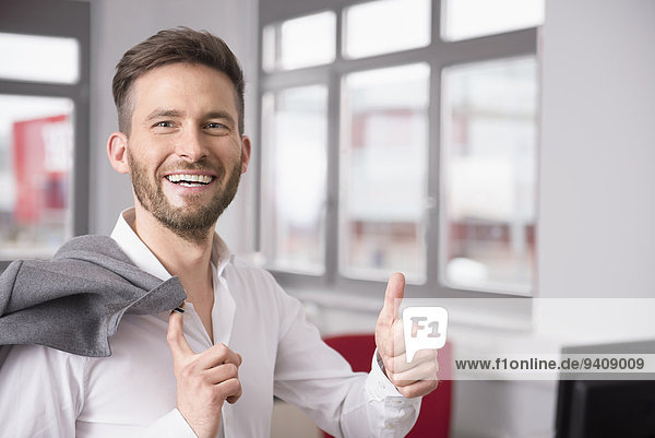 Young man office thumbs up sign smiling