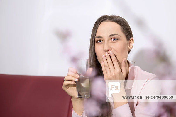 junge Frau junge Frauen Wasser Couch trinken rülpsen