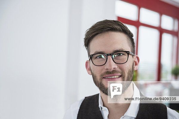 Young businessman office smiling portrait glasses