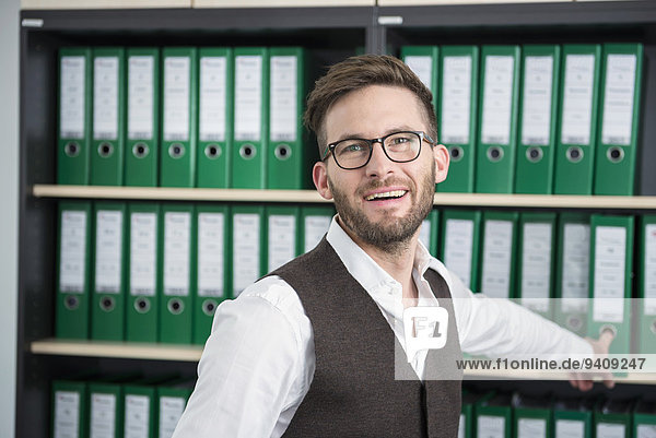 Man young office shelves filing cabinet smiling