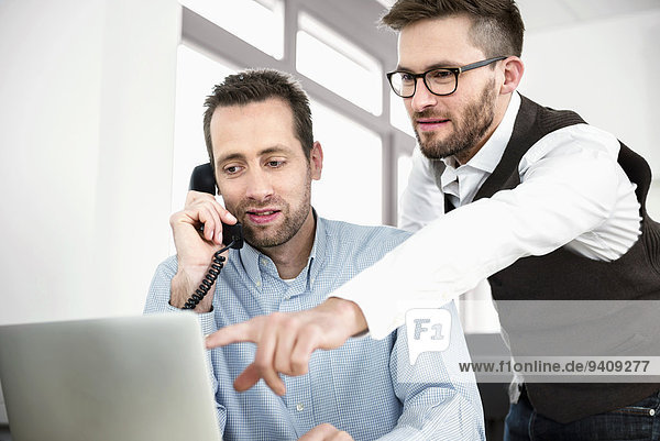 Two men telephone talking computer meeting