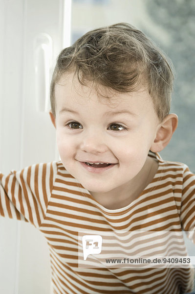 Boy playing with curtain  smiling