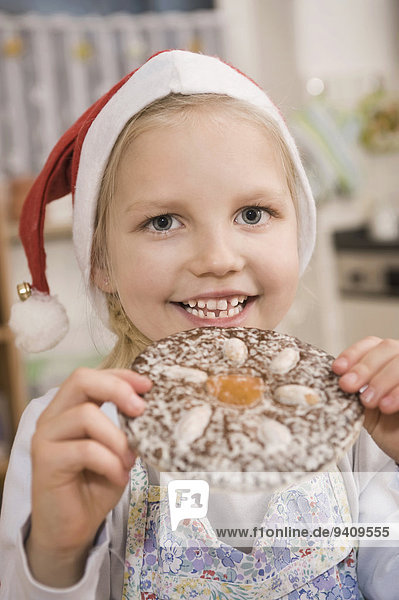 Portrait lächeln Lebkuchen essen essend isst Mädchen Keks