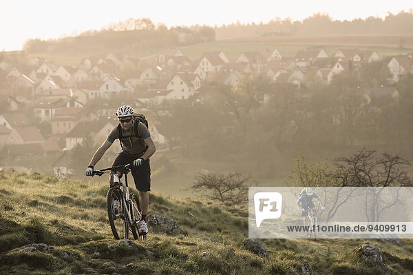 Young men mountainbiking at sunrise