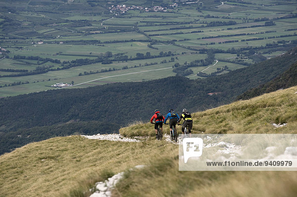 three mountain bikers on the way downhill  Vipava valley  Istria  Nanos  Slovenia