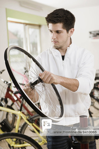 Mann arbeiten jung Fahrrad Rad Fahrradreifen Reifen