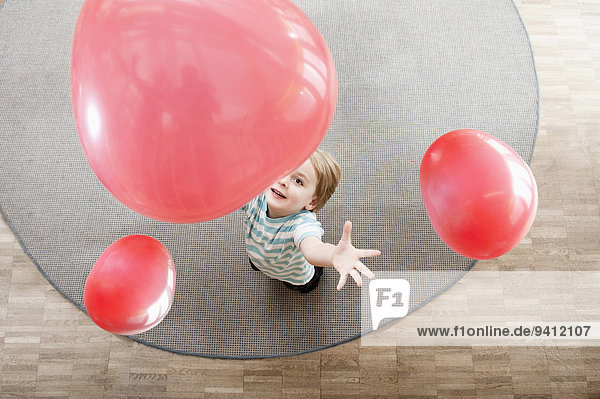Erhöhte Ansicht Aufsicht Kindergarten Junge - Person klein Luftballon Ballon rot spielen