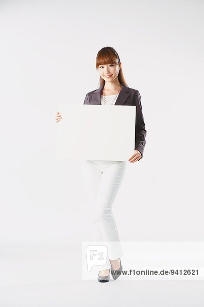 Full length portrait of Japanese young businesswoman against white background