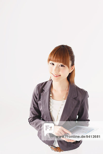 Half length portrait of Japanese young businesswoman against white background