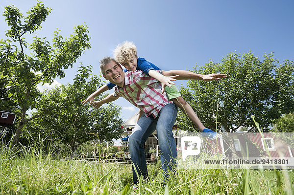 Son boy father piggyback garden playing fun