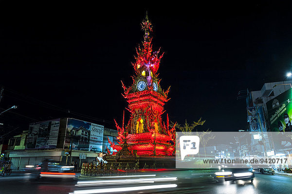 Colourfully illuminated Clock Tower at night with light trails of vehicles Wiang Mueang Chiang Rai Province Chiang Rai Province Northern Thailand Thailand