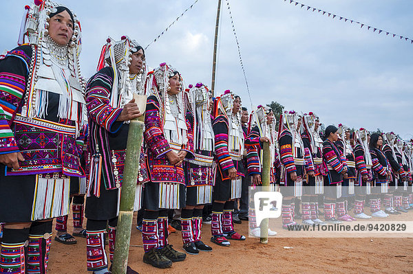 Traditionally dressed women from the Akha people hill tribe ethnic minority dancing New Year's celebrations Chiang Rai Province Northern Thailand Thailand