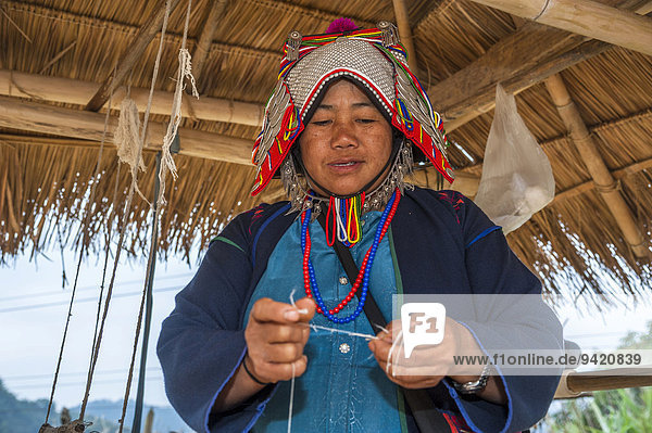 Traditionell gekleidete Frau aus Akha  Bergstamm oder Bergvolk  ethnische Minderheit  beim Weben  Provinz Chiang Rai  Nordthailand  Thailand
