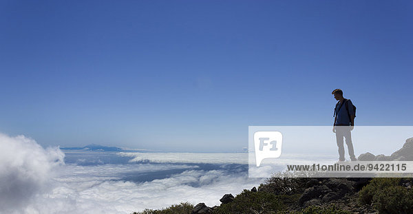 Junger Mann blickt über Wolkendecke  La Palma  Kanarische Inseln  Spanien