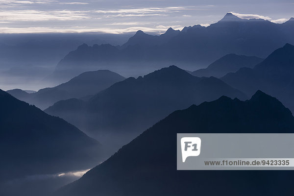 Blaue Stunde mit Berggipfeln des Ammergebirges  hinten die Zugspitze  Reutte  Außerfern  Tirol  Österreich