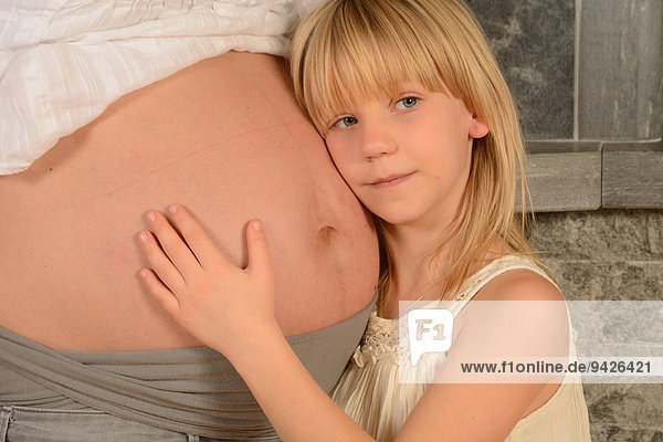 Girl  8 years  with her head at her pregnant mother's stomach  Sweden