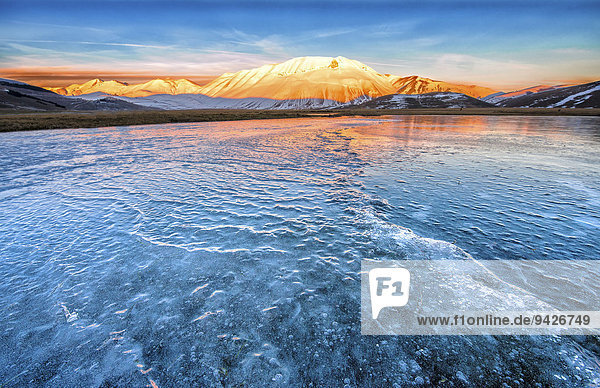 Monte Vettore in the evening light with a frozen puddle with small waves  Monti Sibillini National Park  Umbria  Italy