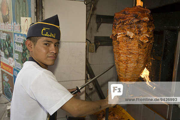 Junger Mann beim Zubereiten von Tacos al Pastor  Puebla  Puebla  Mexiko