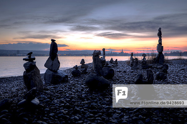 Cairns on the shores of Lake Constance  with the Cathedral of Constance in the evening light  Baden-Wuerttemberg  Germany  Europe