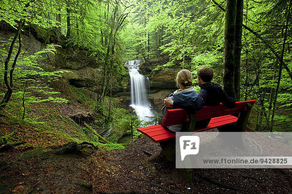 Paar auf Sitzbank am Hasenreuter Wasserfall mit Scheidegg Allgäu Deutschland Europa