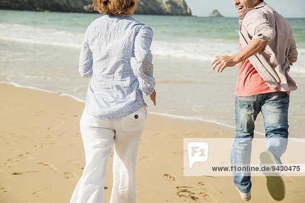 Mature couple running on beach  Camaret-sur-mer  Brittany  France