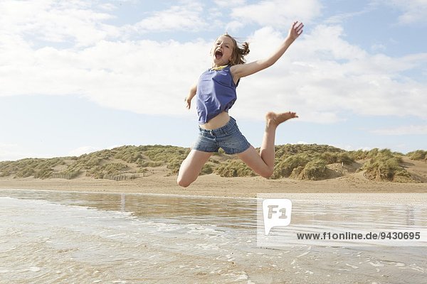 Mädchen springen in der Luft am Strand,  Camber Sands,  Kent,  UK