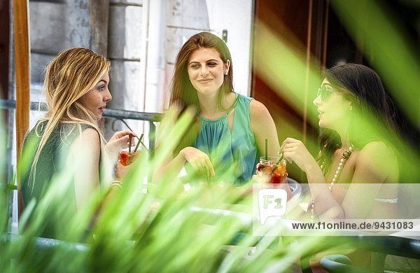Drei junge Freundinnen beim Cocktail im Straßencafé  Cagliari  Sardinien  Italien