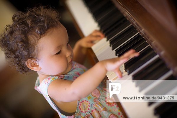 Süßes kleines Mädchen beim Klavierspielen